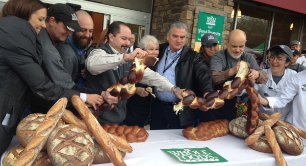 Store Manager and district amnager breeak the 6 foot long challah bread instead of the traditional ribbon cutting at the grand re-opening of Whole Foods in Cary at Waverly Place on March 5,2014